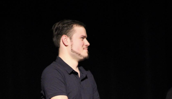 Cole Vianello listens on stage to recognition comments by Ms. Larson for his outstanding work as a yearbook staffer.